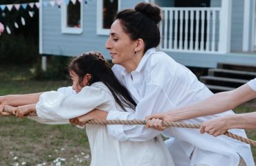 Family enjoying a playful tug of war game outdoors, showcasing teamwork and fun.